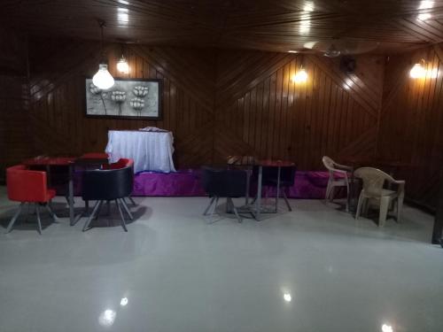 a dining room with tables and chairs in a barn at Hotel Kameng in Itānagar