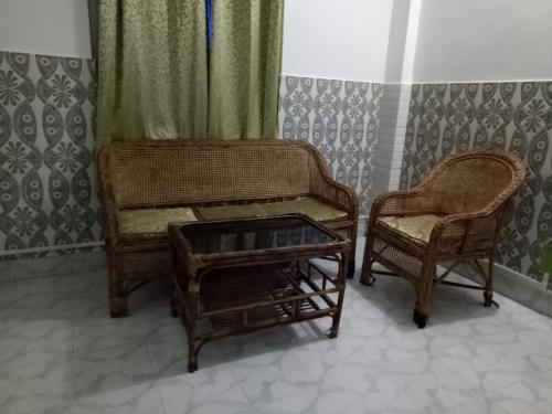 two wicker chairs and a table in a room at Hotel Kameng in Itānagar
