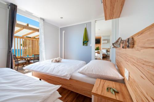 a bedroom with two beds and a view of the ocean at Adria Village Superior Mobile Homes in Pakoštane