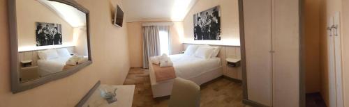 una camera d'albergo con letto e specchio di Hotel Locanda Dolce Vita a San Donà di Piave