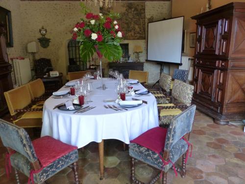 a dining room with a white table and a vase of flowers at Château du Grand Jardin in Valensole