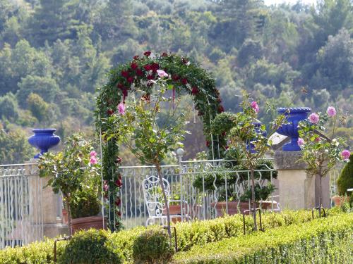 a garden with an arch with flowers on a fence at Château du Grand Jardin in Valensole