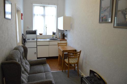 a living room with a couch and a kitchen at Welcome Holiday Flats in Skegness