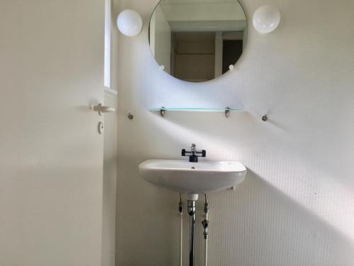 ein Bad mit einem Waschbecken und einem Spiegel in der Unterkunft Feriecenter & Vandland Øster Hurup in Øster Hurup