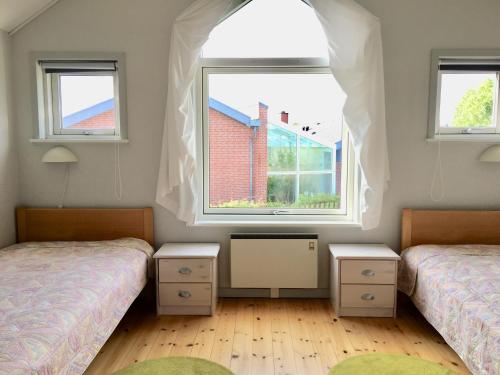 two beds in a room with two windows at Feriecenter & Vandland Øster Hurup in Øster Hurup