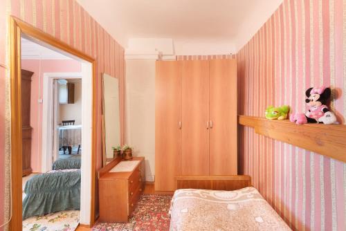 スーズダリにあるАпартаменты в Кремлеのピンクの壁のベッドルーム(鏡、ベッド付)
