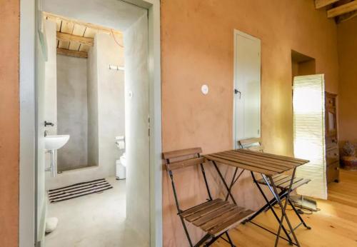 OxiáにあるSerene Stone Houseの木製テーブル、バスルームが備わる客室です。