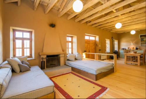 a large room with two beds and a fireplace at Serene Stone House in Oxiá