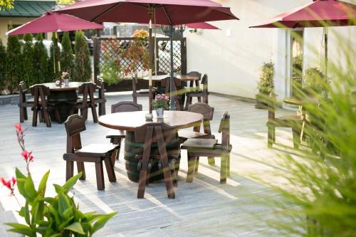 a patio with tables and chairs and umbrellas at Pension Knoll in Schörfling