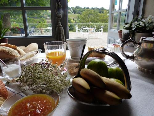 a table with a bunch of food and a bowl of fruit at Château du Grand Jardin in Valensole