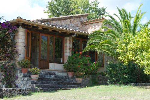 a small stone house with potted plants on the stairs at Can Petrel in Pollença