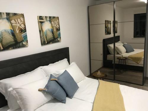 um quarto com uma cama com almofadas e um espelho em Korcula Holiday em Korčula