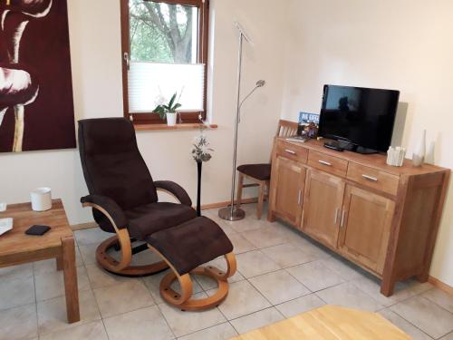 a living room with two chairs and a flat screen tv at Ferienwohnung Adams in Hinterweiler
