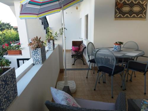 a balcony with a table and chairs and an umbrella at Quintal d'Angra in Angra do Heroísmo