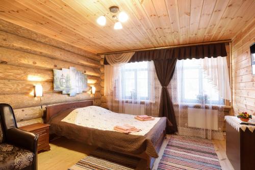 スーズダリにあるNa Kremlevskom Bereguの木製の部屋にベッド1台が備わるベッドルーム1室があります。