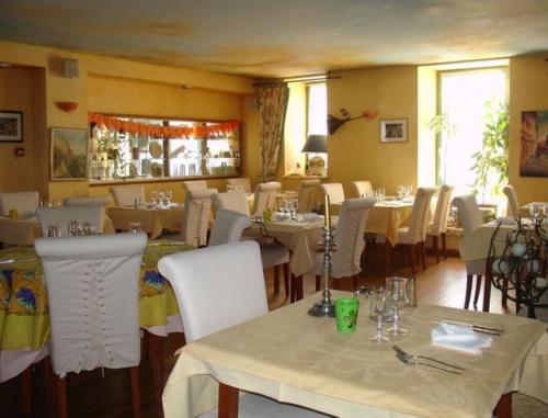 a restaurant with white tables and white chairs at Auberge de Marville in Marville