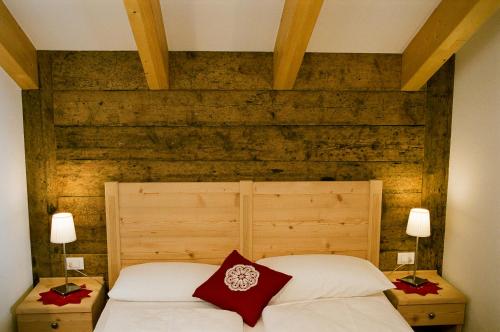 a bedroom with a white bed with red pillows at Appartements Josef Lercher in San Candido