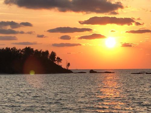 a sunset over a body of water at Shirahama Hotel in Nago
