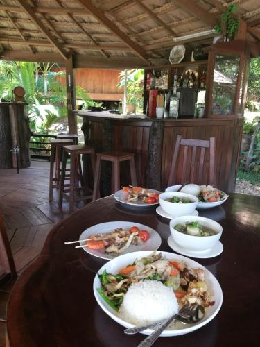 un tavolo con sopra piatti di cibo e riso di Nirvana Archipel Resort a Vang Vieng
