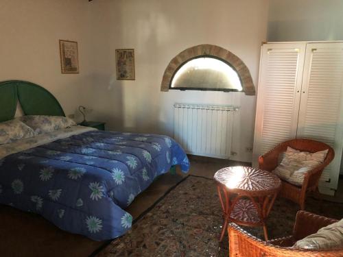 a bedroom with a bed and a window and a chair at Casa di Romano, La Piazzetta in Tavarnelle in Val di Pesa