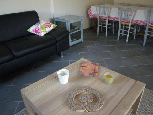 a living room with a black couch and a coffee table at La maison des Prouges in Fuissé