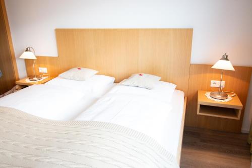 2 Betten in einem Hotelzimmer mit 2 Lampen in der Unterkunft Haus Mariella in Podersdorf am See