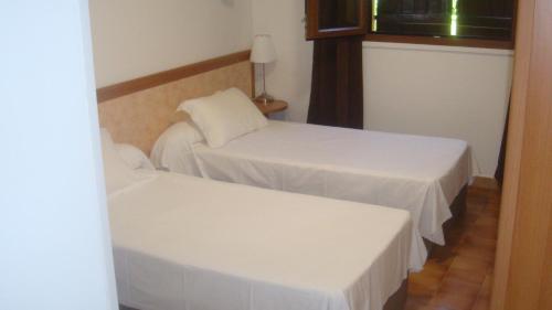 two beds in a room with white sheets at Le FLORIDA in Zicavo