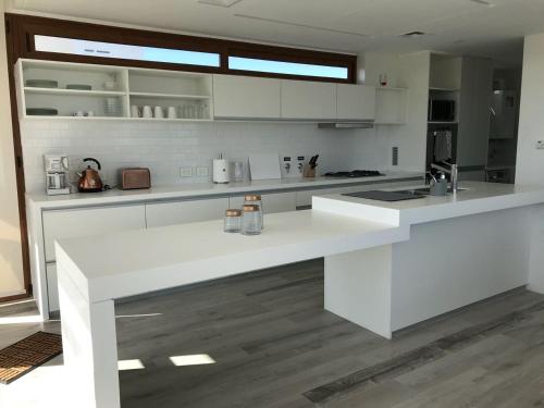 a white kitchen with a large white counter top at Aizarker in La Plata