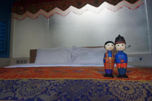 two figurines standing on top of a bed at Manggis Garden Dive Resort in Candidasa