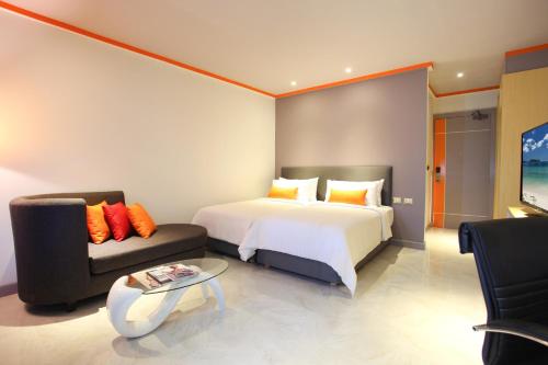 a bedroom with a bed and a couch and a table at Chabana Kamala Hotel in Kamala Beach