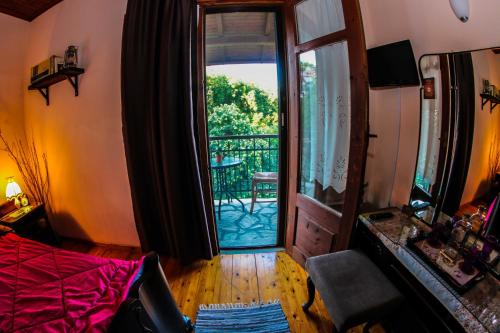 una camera da letto con porta che si apre su un balcone con tavolo di Mylos ad Arkochórion