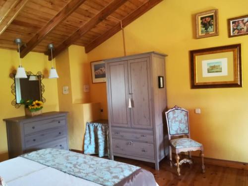 a bedroom with a bed and a cabinet and a chair at El Mirador del Gato I y II in Mesegar de Corneja