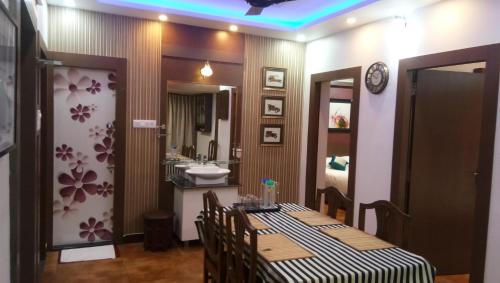 a dining room with a table and a sink at Square Suite in Mangalore