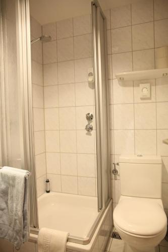 a bathroom with a white toilet and a shower at RTB-Hotel - Sportschule in Bergisch Gladbach