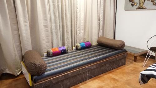 a couch in a living room with a window at Square Suite in Mangalore