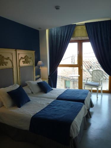 a bedroom with two beds and a large window at Los Calaos de Briones in Briones