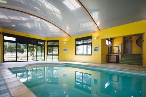 an indoor swimming pool with an arched ceiling at Hotel Du Donon in Grandfontaine