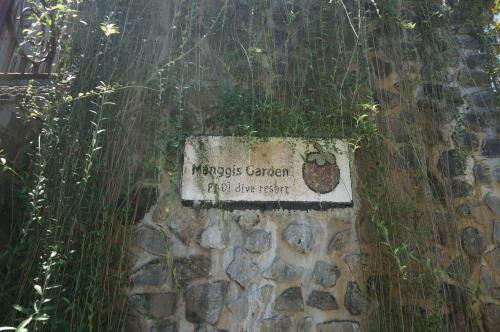 a sign on the side of a stone wall at Manggis Garden Dive Resort in Candidasa