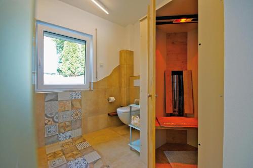 bagno con servizi igienici e finestra. di Ferienhaus Köppel a Bad Staffelstein