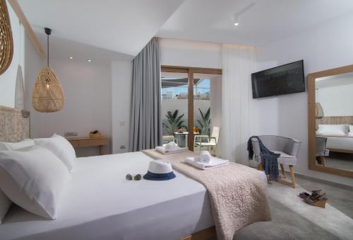 a bedroom with a large white bed with a mirror at Harma Boutique Hotel in Hersonissos