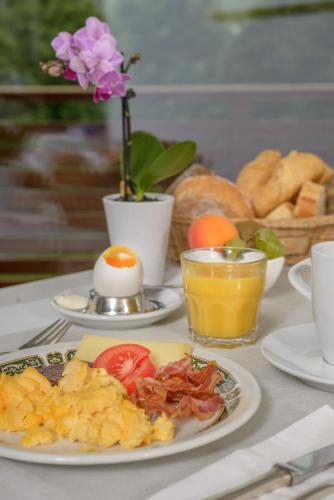 a table with a plate of breakfast food and an egg at dala Hotel & Apartments in Leukerbad