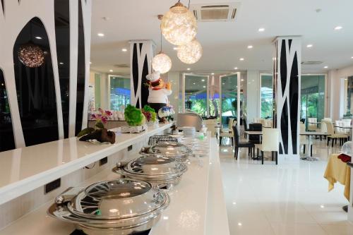 un bancone con molti piatti sopra in un ristorante di Grand Hill Resort and Spa a Nakhon Sawan