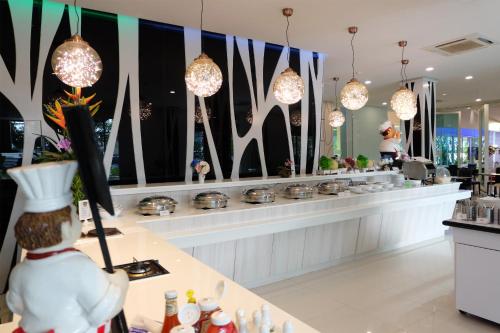 un ristorante con bancone con pentole e padelle di Grand Hill Resort and Spa a Nakhon Sawan