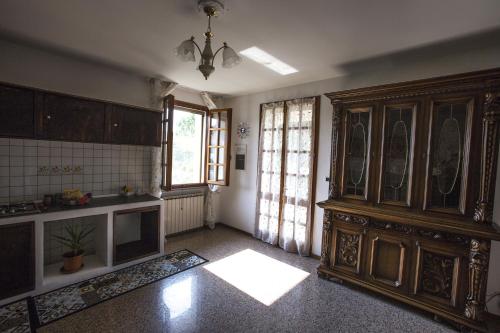 a kitchen with a large wooden cabinet in a room at Villa Berra - Via Postale 63/A in Berra