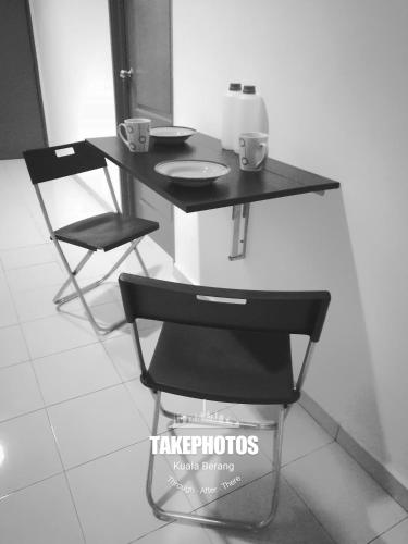 a table and a chair with two cups on it at One Homestay @ Kirana in Kuala Berang