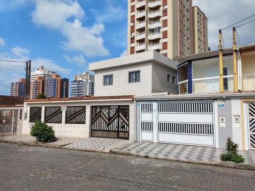 a white building with a gate in a city at Pousada do Chileno in Praia Grande