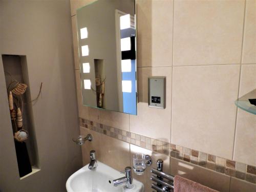 a bathroom with a sink and a mirror at Whitehaven Guest House in Whitby