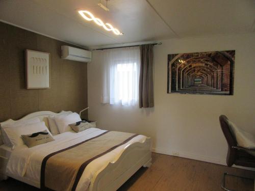 a hotel room with a bed and a window at Hotel Le Griffon in Abidjan