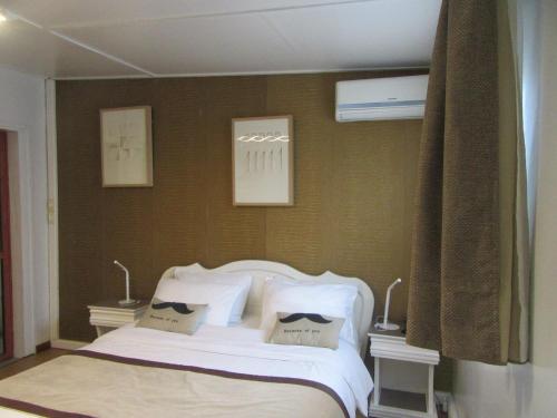 a bedroom with a bed with white sheets and pillows at Hotel Le Griffon in Abidjan