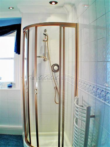 a shower with a glass enclosure in a bathroom at Whitehaven Guest House in Whitby